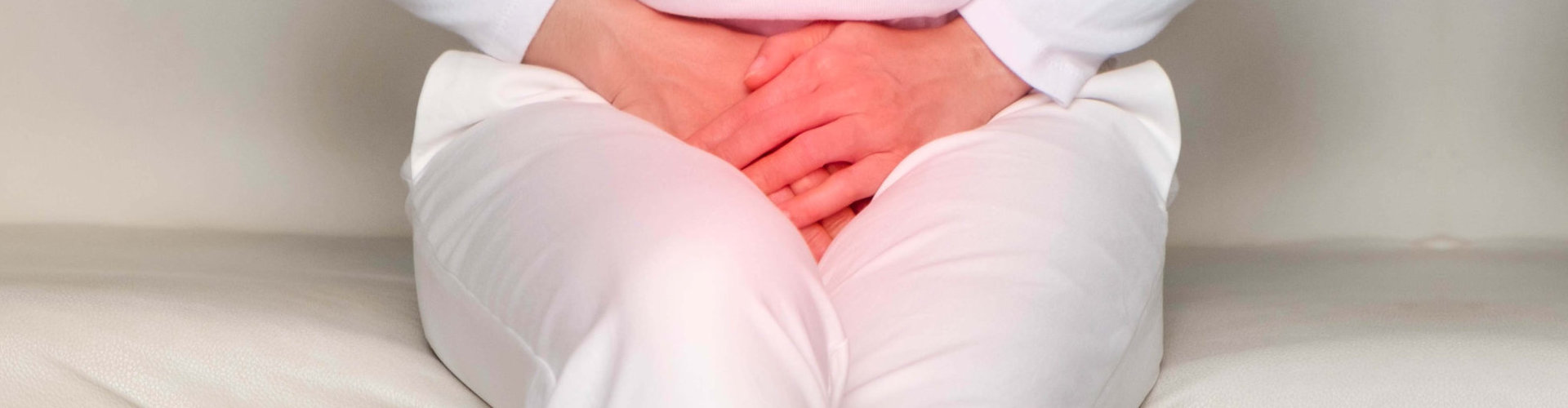 woman with hands holding her crotch in pain. Bladder pain.